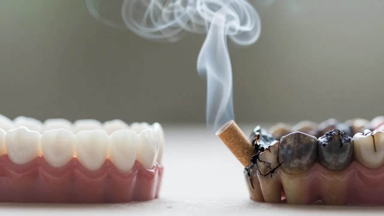 Přechod od bílých zubů k poškozeným, symbolizovaný kouřem, který je příčinou poškození.